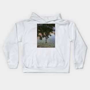 Stone sea surface in pristine clear water under a fir tree Kids Hoodie